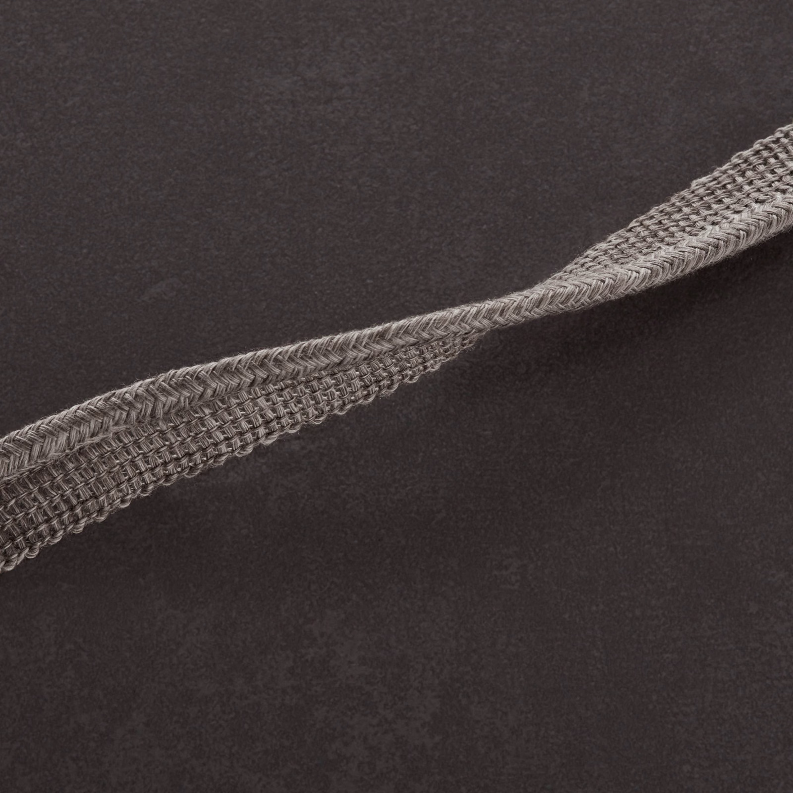 Charcoal-grey textile with softly mottled ground and raised diagonal braided detail