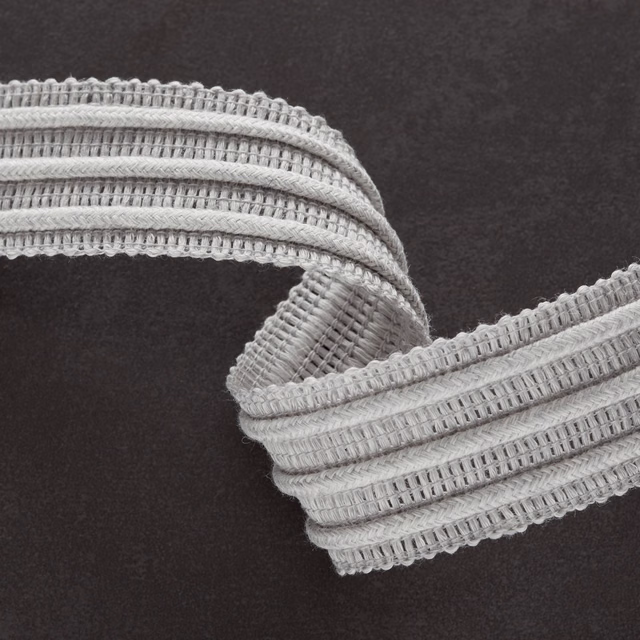 Close-up of cool dove-grey ribbed fabric with raised bands and scalloped woven edges