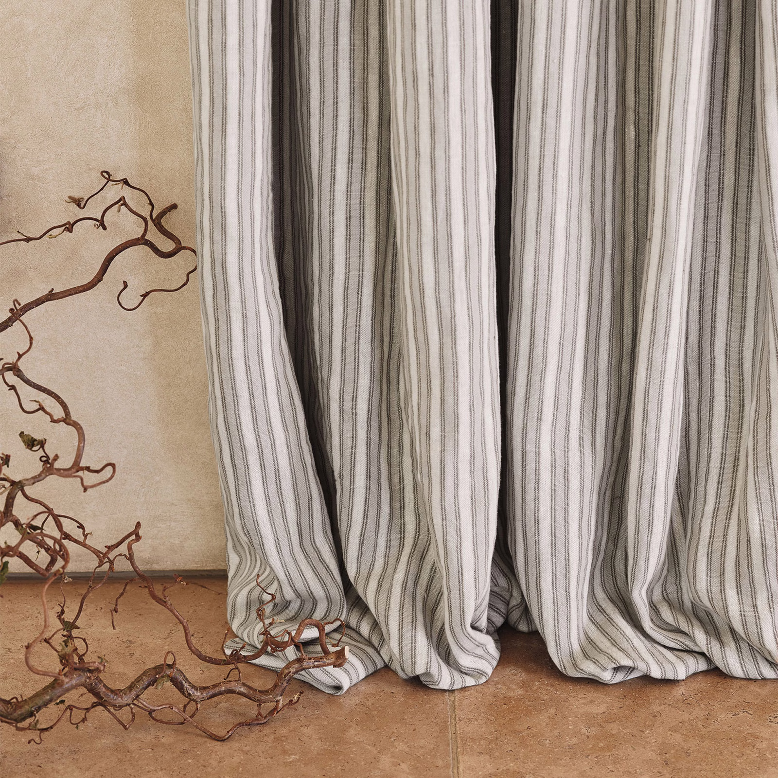 Muted cement-grey fabric with fine irregular vertical stripes in soft folds