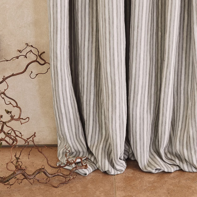 Muted cement-grey fabric with fine irregular vertical stripes in soft folds
