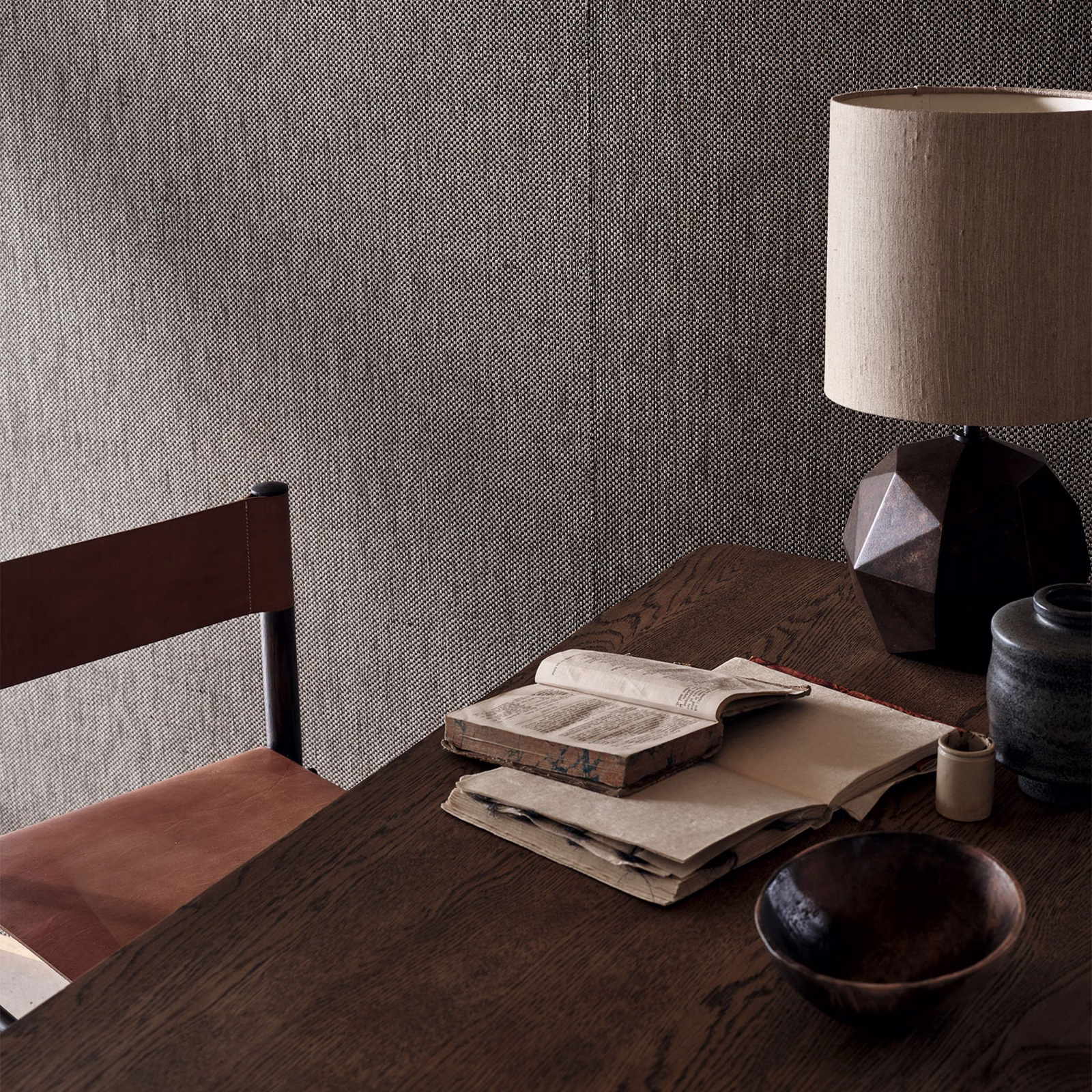 Cool gunmetal-grey textured wallpaper with fine woven grain on a shaded wall