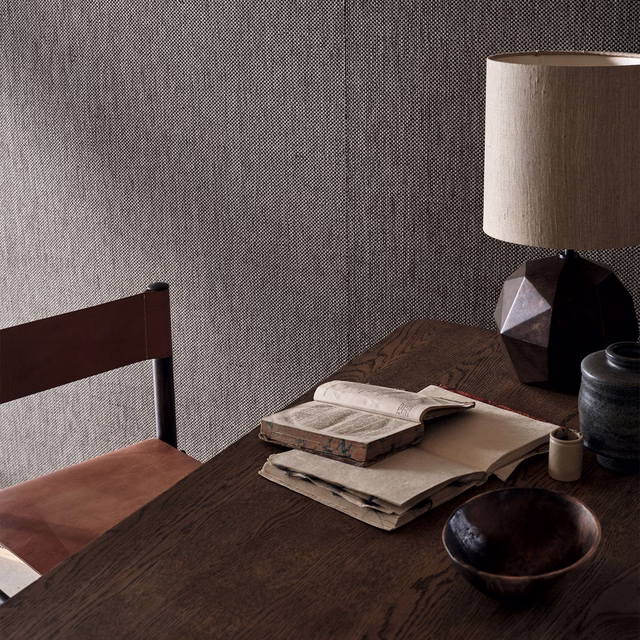 Cool gunmetal-grey textured wallpaper with fine woven grain on a shaded wall