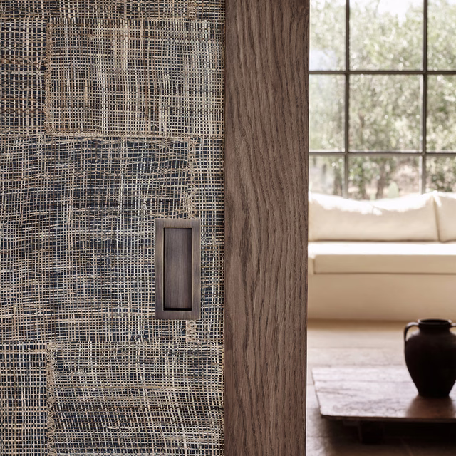Atlantic blue-grey wallpaper with irregular woven grid texture beside warm timber panelling