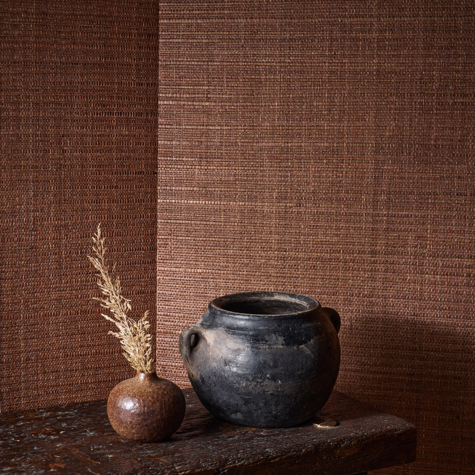 Warm paprika-brown woven wallpaper with fine horizontal texture and subtle tonal variation