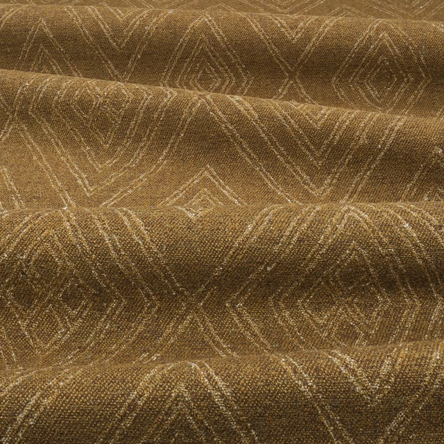 Bronze-brown woven fabric with muted gold chevron lines and tactile pebbled texture