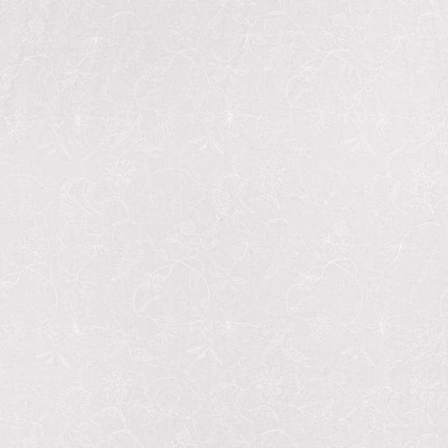 White-on-white fabric with delicate embroidered flowers, curling stems and a fine textured ground