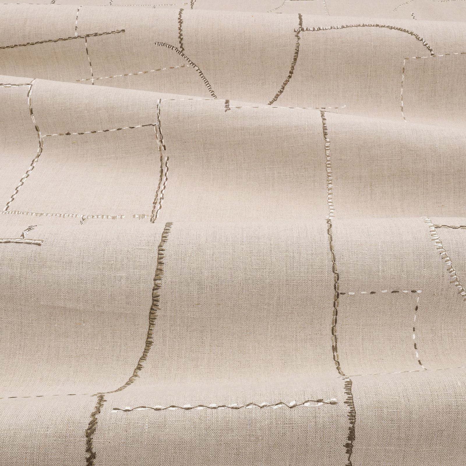 Warm flax-beige fabric with irregular embroidered rectangles and a fine woven surface