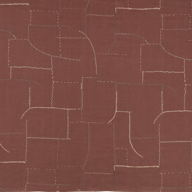 Warm sienna fabric with pale embroidered lines forming an irregular geometric grid