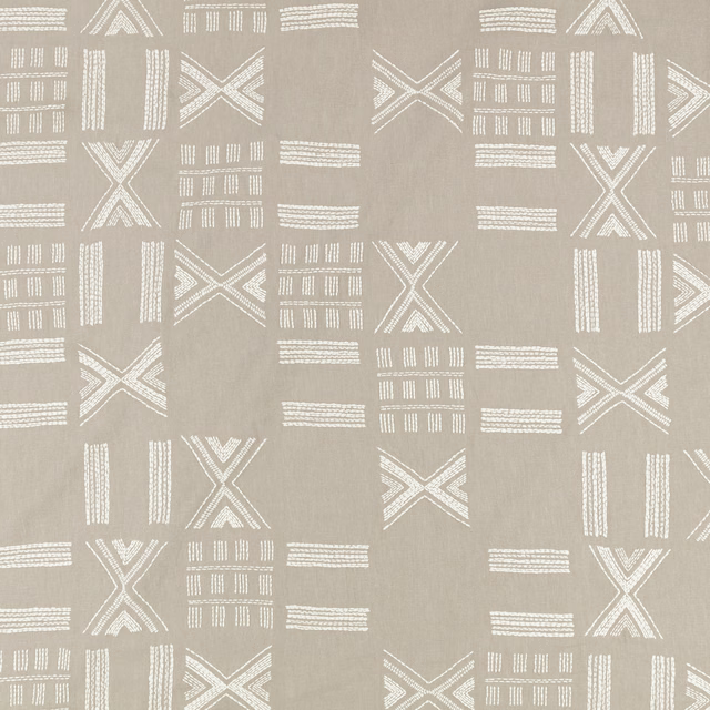 Warm flax-taupe textile with white embroidered Xs, bars and gridded geometric motifs