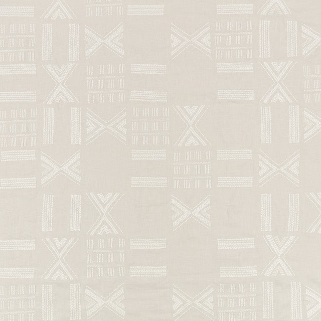 White-sand textile with ivory geometric X motifs and raised linear embroidery