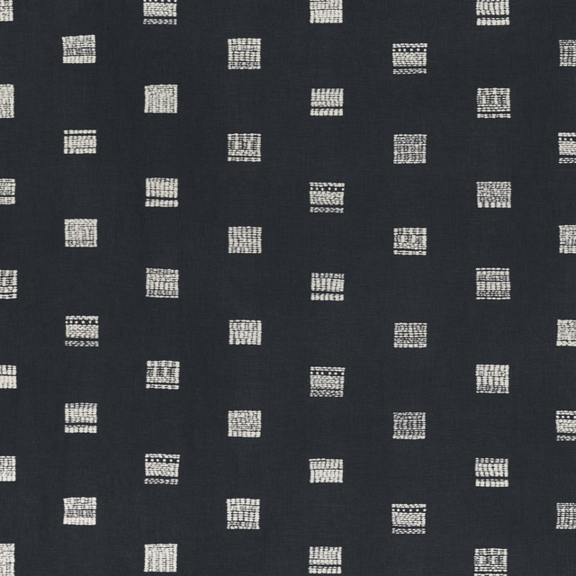 Dark indigo cloth with scattered cream grid-like square motifs and subtle woven texture