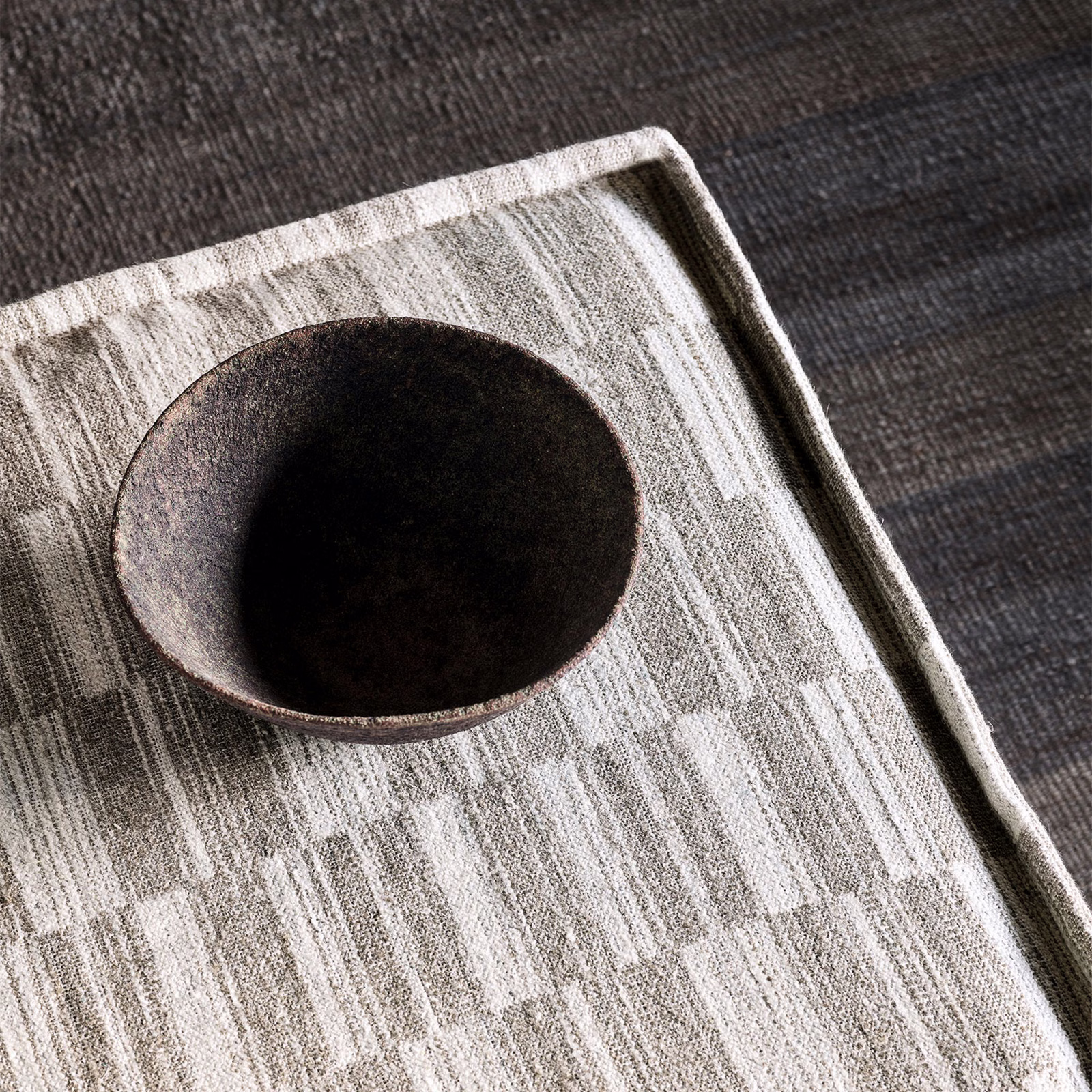 Cool grey woven fabric with broken pale vertical bars and softly mottled texture
