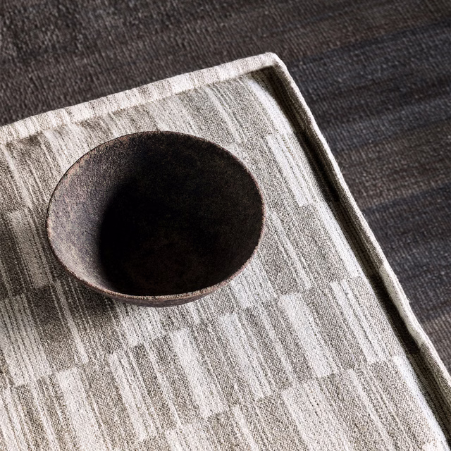 Cool grey woven fabric with broken pale vertical bars and softly mottled texture