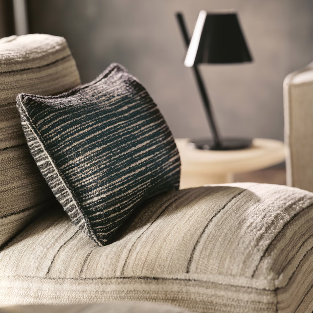 Warm parchment-beige upholstery with irregular dark striations and a ribbed woven surface