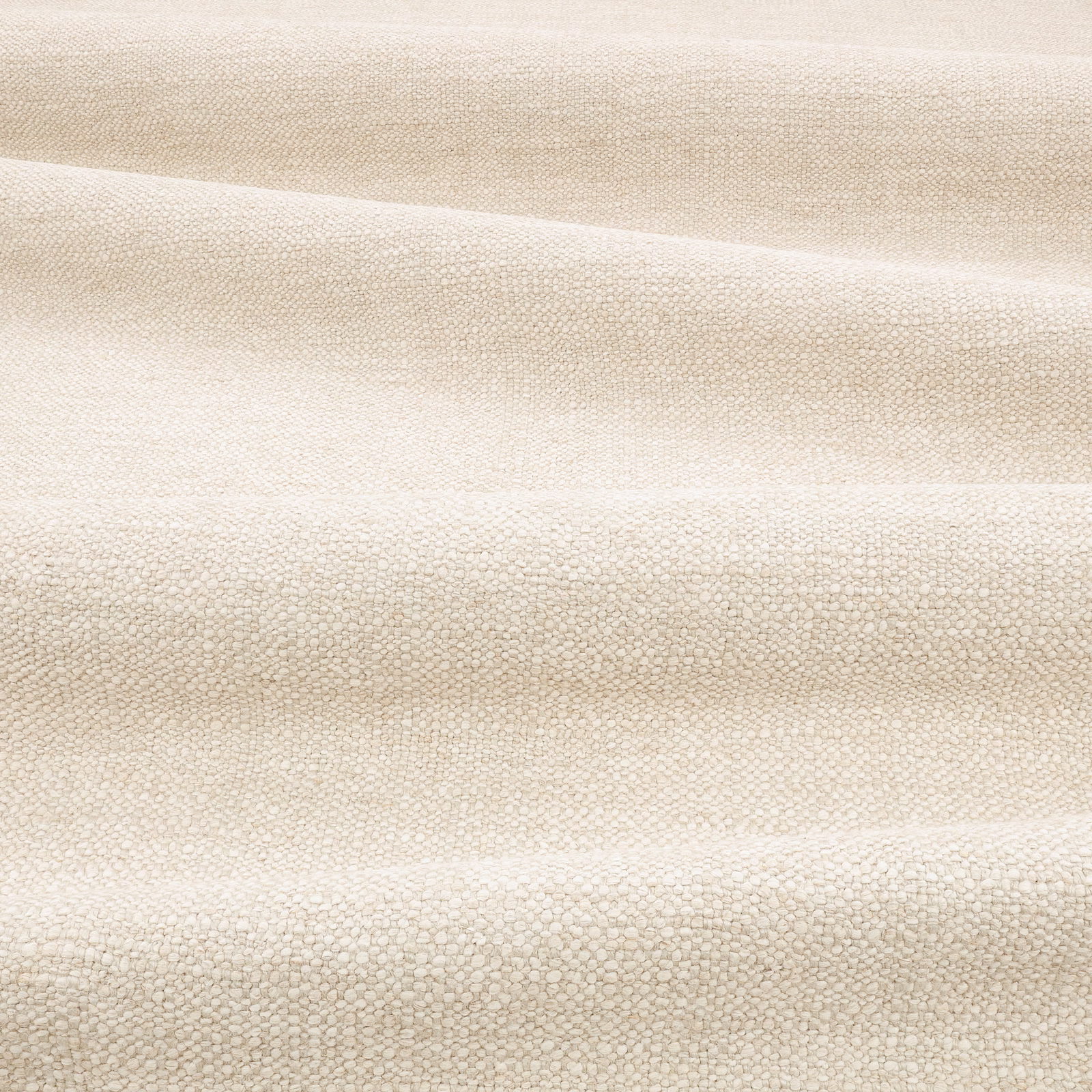 Warm fossil-beige textile with tiny pebbled weave and softly shifting horizontal folds