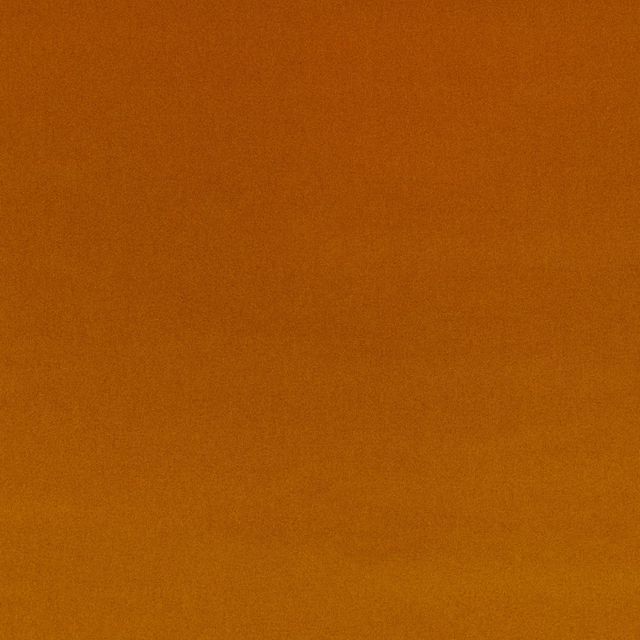 Close-up of plain burnt carnelian-orange velvet with a softly shifting pile