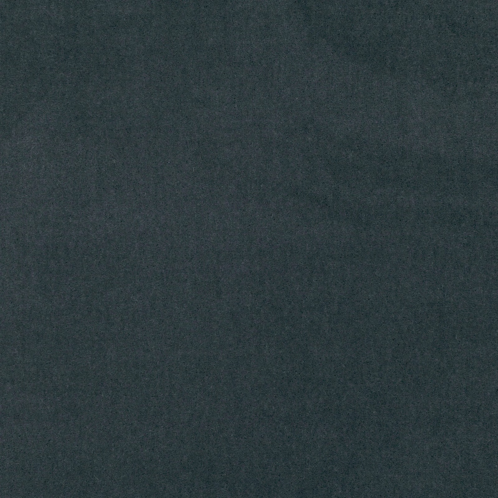 Close-up of deep charcoal velvet with a cool blue-green cast and softly shifting nap