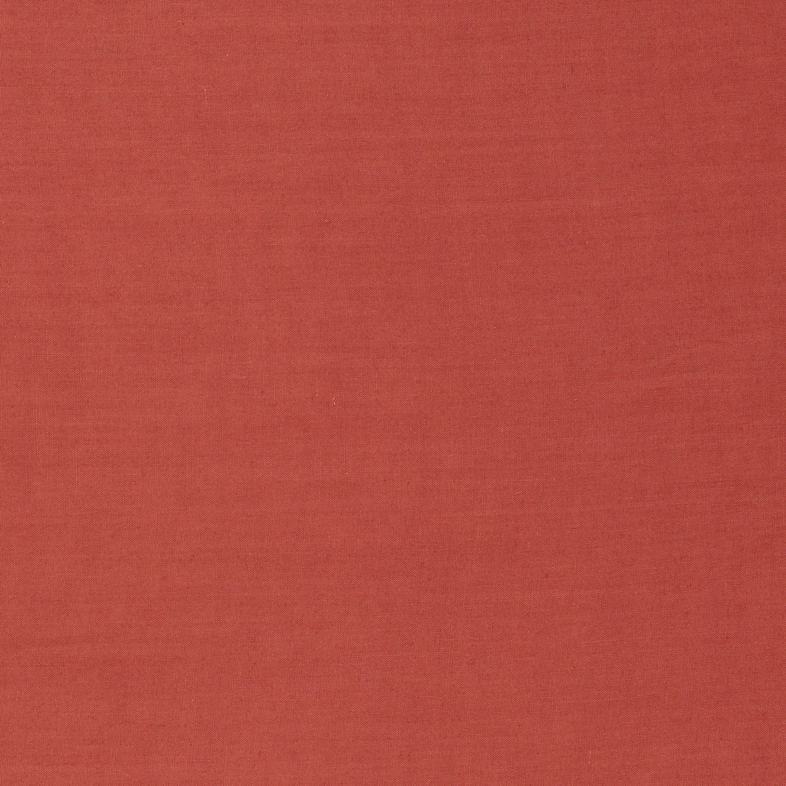 Close-up of warm carmine-red woven fabric with a subtle fine-grained texture