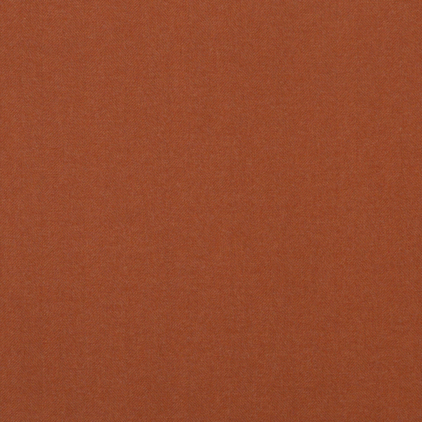 Close-up of warm burnt amber wool with a fine, even woven texture.