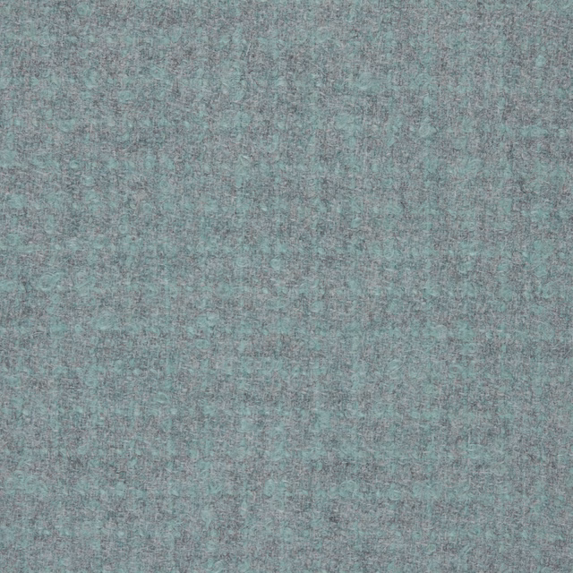Close-up of cool slate-grey bouclé with blue-green flecks and mottled texture