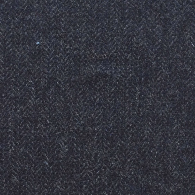 Close-up of dense dark navy textile with blue-grey flecks and diagonal woven texture