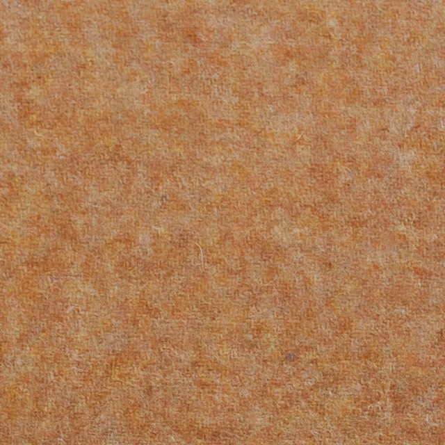 Close view of warm ginger-orange fabric with pale mottled flecks and dense texture