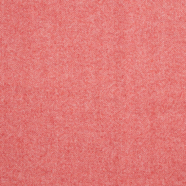 Close-up of muted flamingo coral fabric with a fine woven herringbone texture