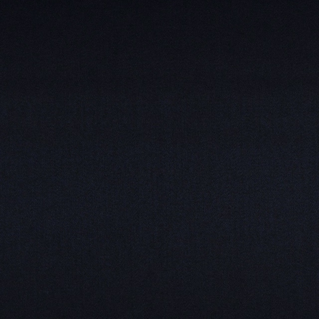 Close-up of blue-black charcoal fabric with a fine, subtly textured plain weave
