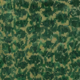 Close-up of abstract moss and emerald green woven fabric on a warm beige ground