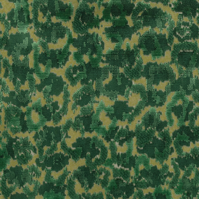 Close-up of abstract moss and emerald green woven fabric on a warm beige ground
