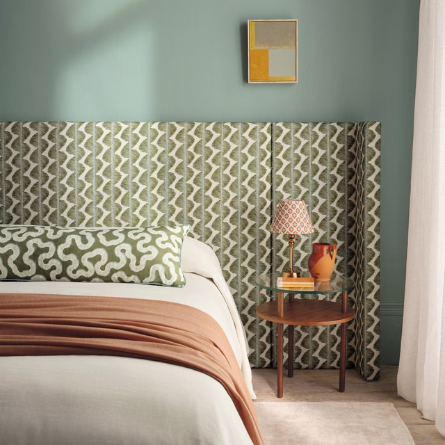 Muted matcha and cream geometric fabric hanging in softly folded vertical curtain panels