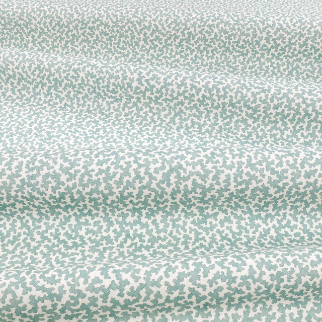 Pale aqua-teal fabric with dense irregular flecks across softly folded cloth