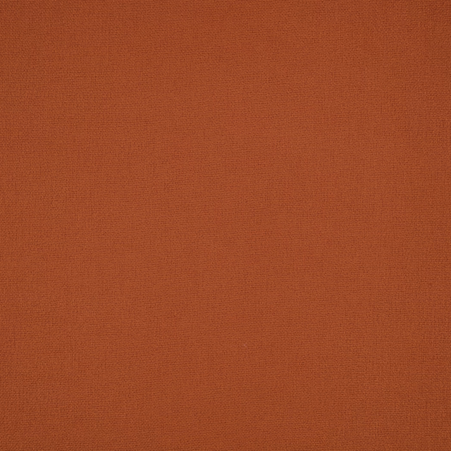 Close-up of Elio Cajun’s finely woven rust-orange plain fabric surface