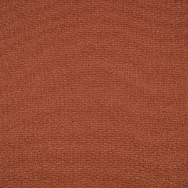 Close-up of warm terracotta fabric with a fine, even woven texture
