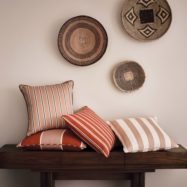 Warm russet cushion with fine ivory woven stripes and soft matte texture
