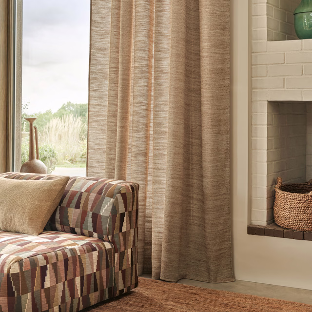 Warm cinnamon-brown slubbed textile falling in softly lit curtain folds