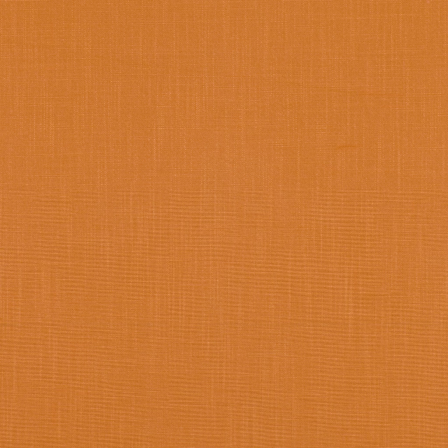 Close-up of warm cinnabar-orange fabric with a fine crosshatched woven texture