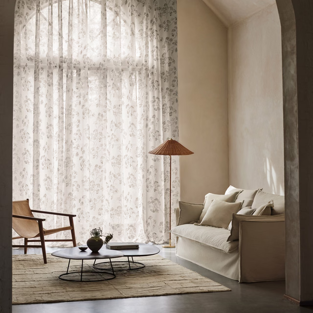 Pale taupe-grey sheer fabric with delicate scattered botanical motifs