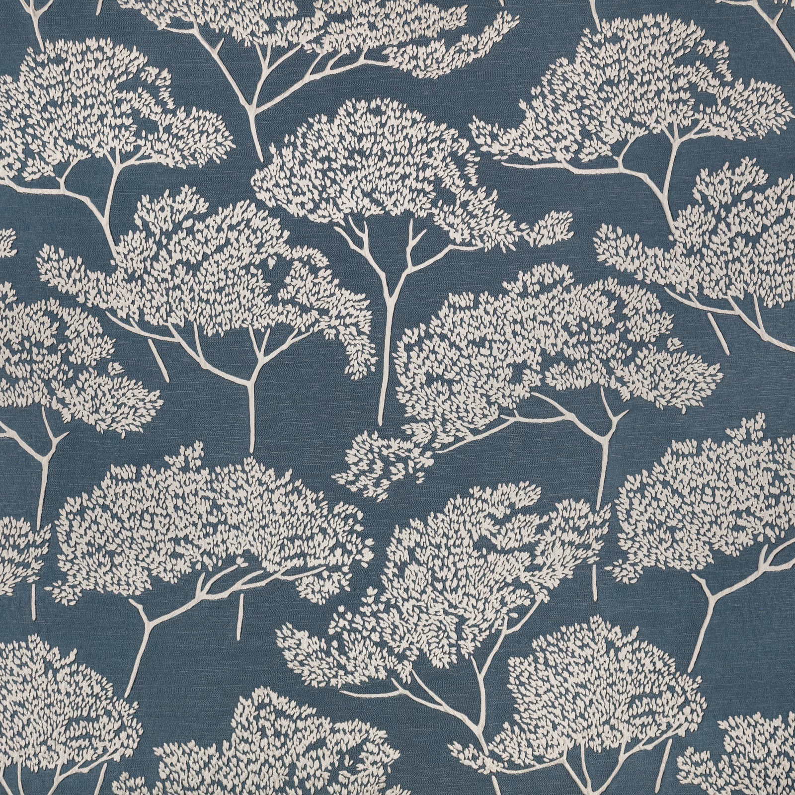 Cream branching tree motifs across a cool gunmetal blue-grey woven textile
