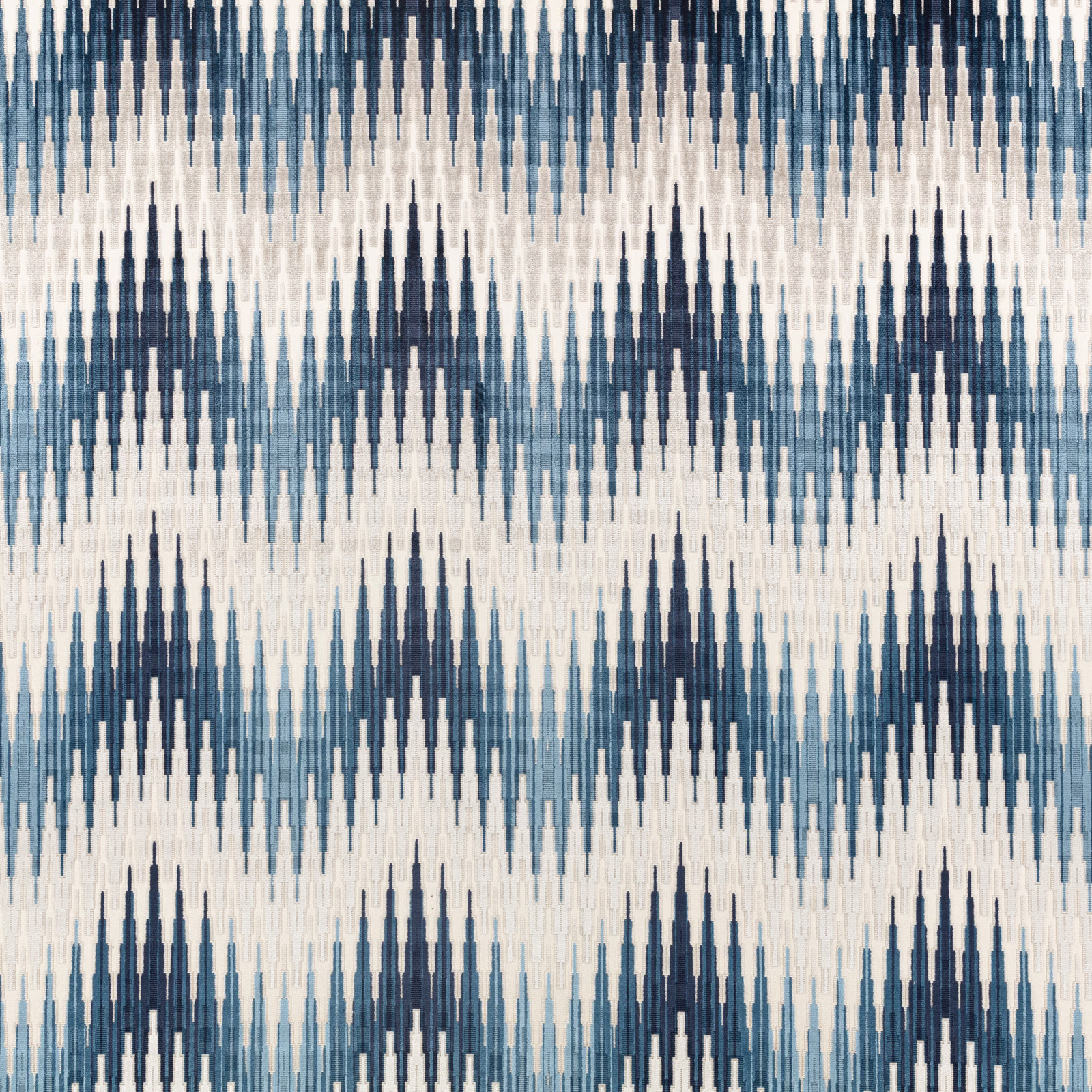 Indigo and pale blue elongated ikat motifs woven across an ivory fabric ground