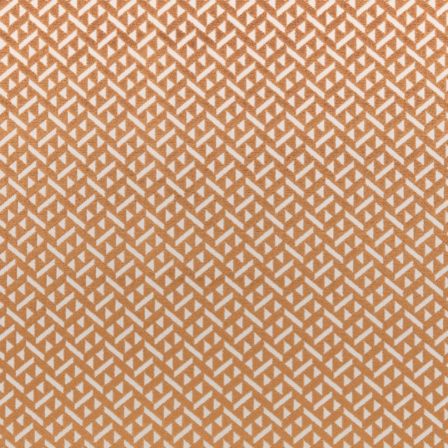 Warm copper fabric with repeating ivory angular motifs and a fine woven texture