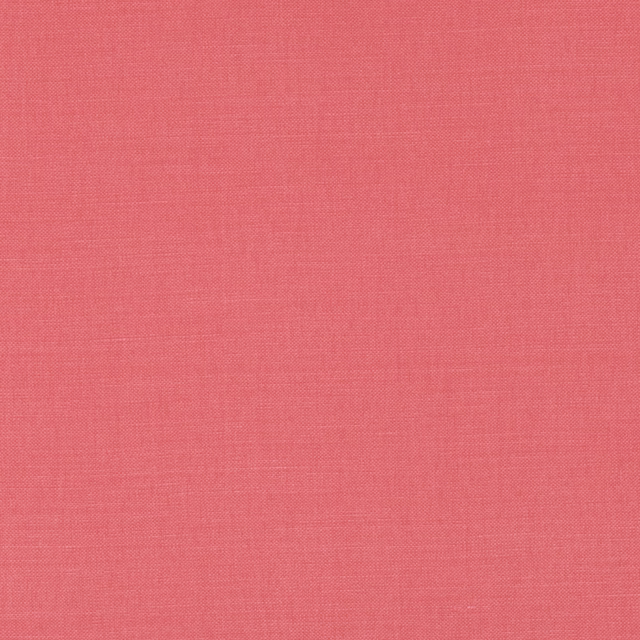 Close-up of warm coral-red plain weave with a fine, softly mottled texture