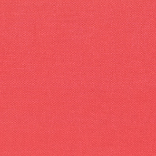 Close-up of Rocoto’s warm coral-red plain weave with fine crosshatch texture
