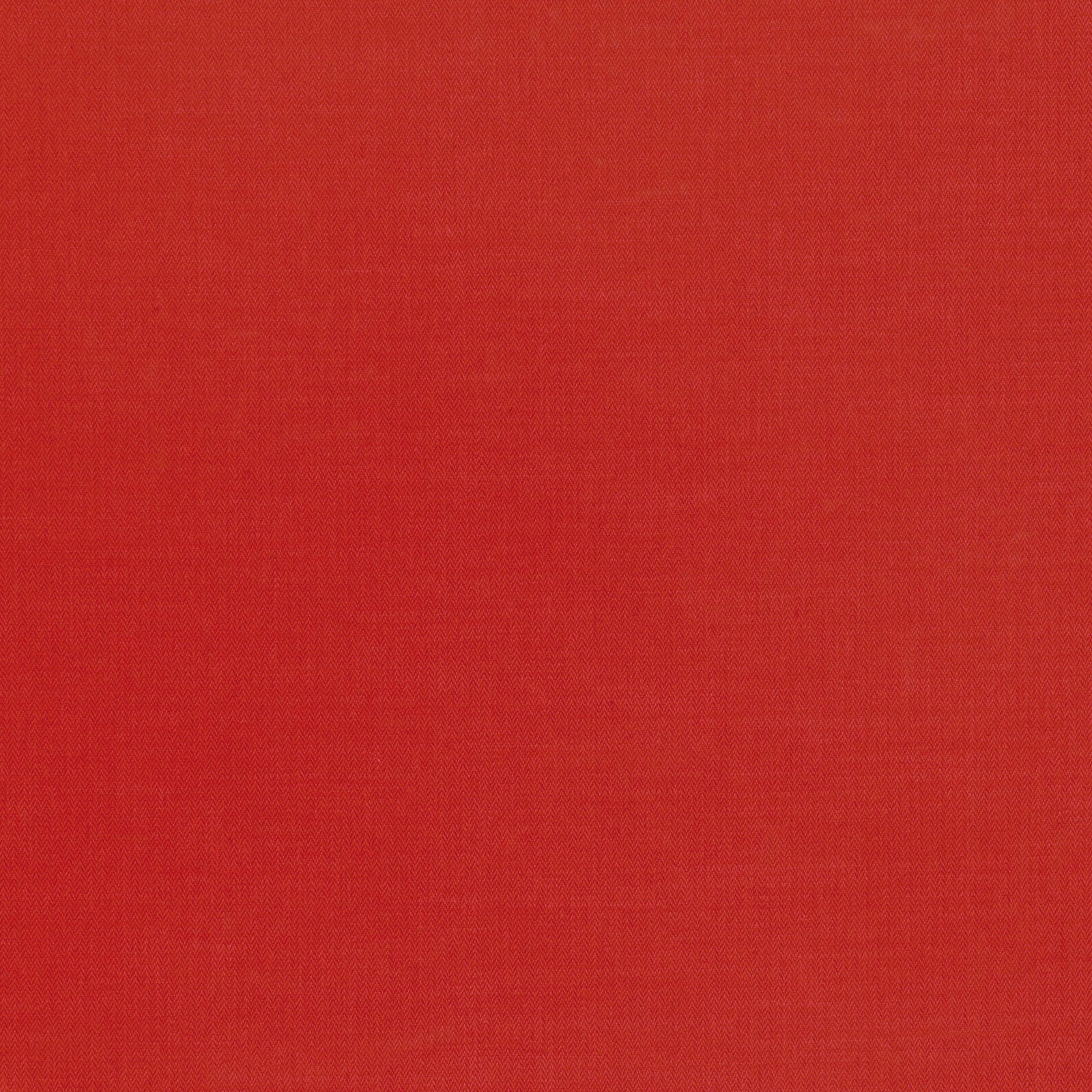Close-up of saturated postbox-red fabric with a subtle fine woven texture