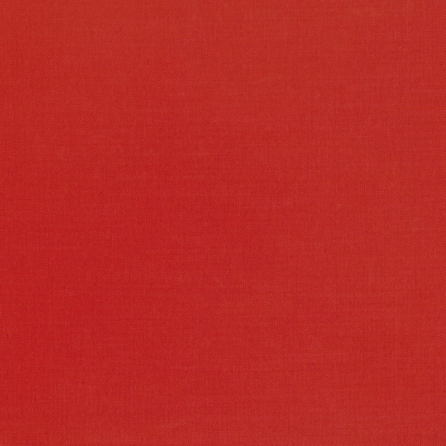Close-up of saturated postbox-red fabric with a subtle fine woven texture