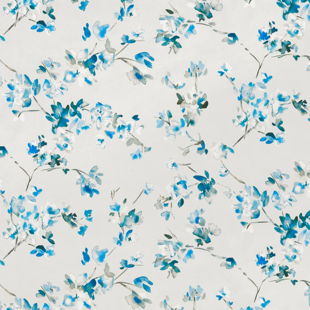 Watercolour-style cobalt and turquoise blossoms scattered over an ivory fabric ground