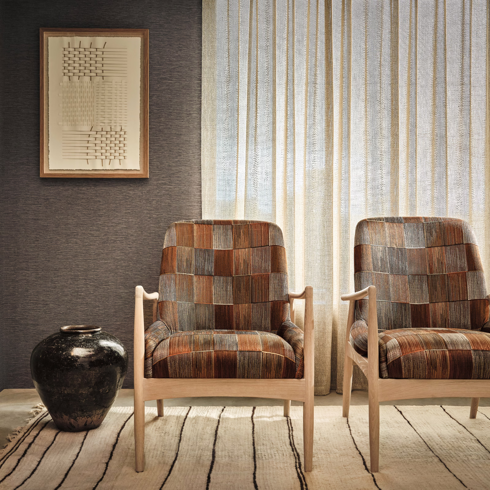 Cinnamon and rust woven blocks with charcoal lines on an upholstered armchair