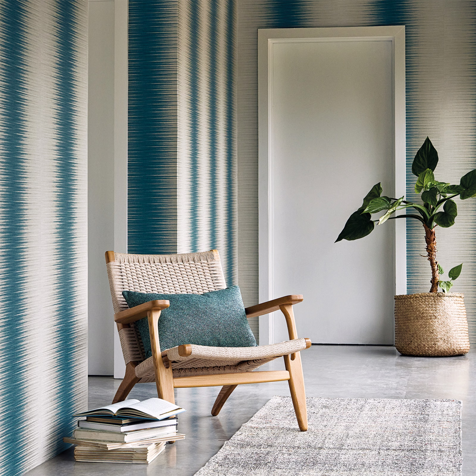 Deep teal and ivory vertical striated wallcovering shown behind a modern chair