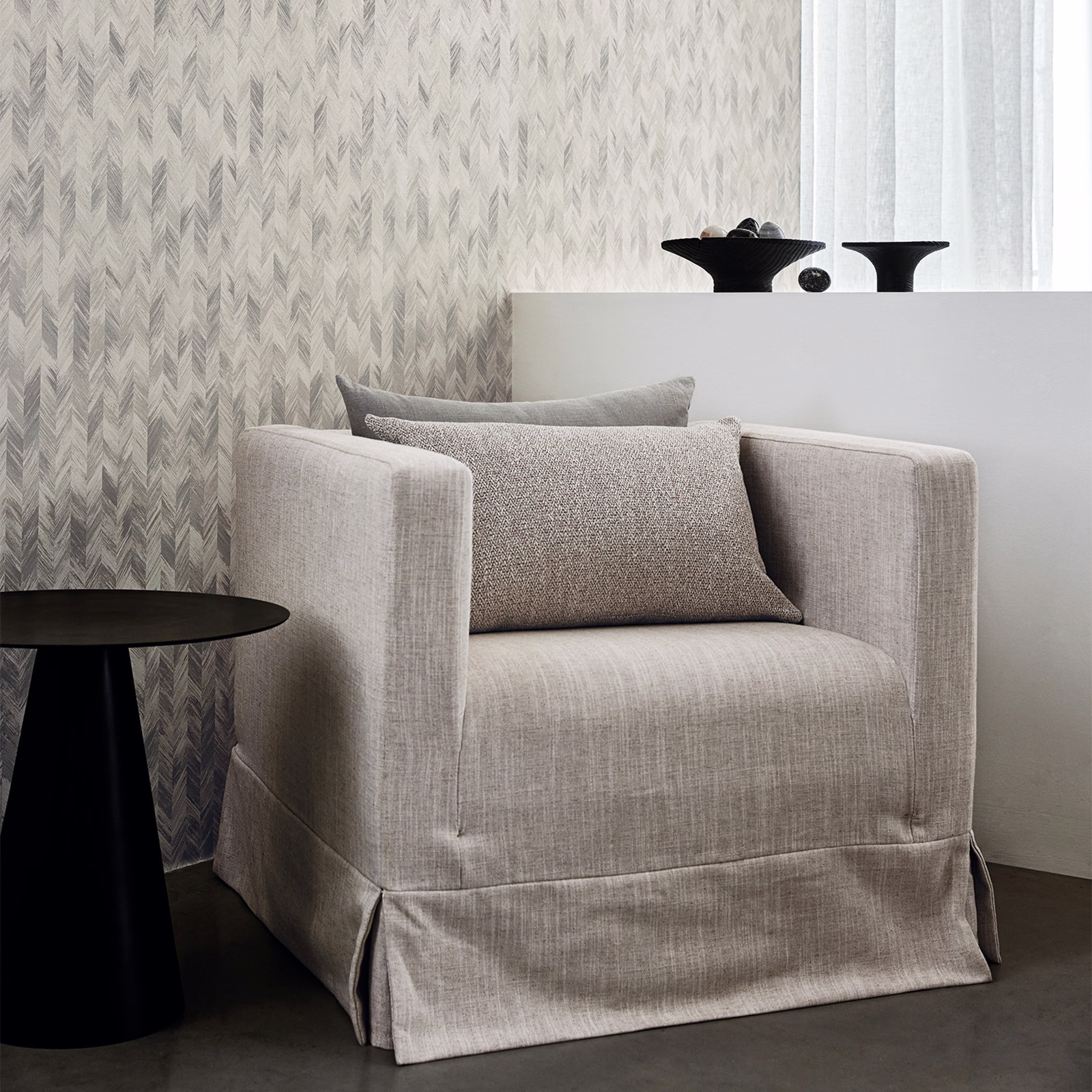 Soft lovat grey-green wallpaper with layered feathered chevrons in a bright room