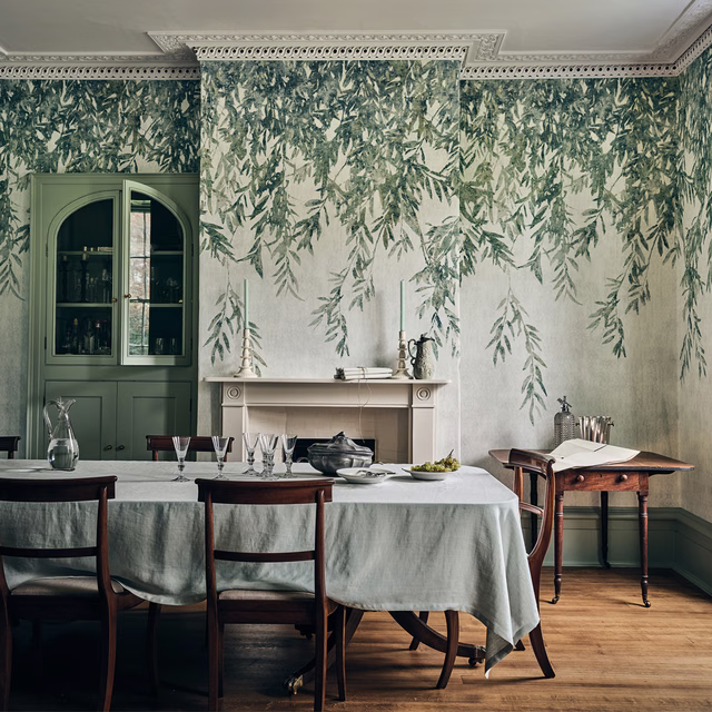 Pale ivory wallpaper with trailing sage foliage framing a traditional dining room